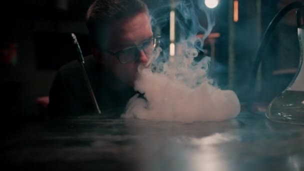 一个年轻人在一个妓女男人身上抽烟吸着浓浓的白烟 这就是吸烟和放松的概念 — 图库视频影像