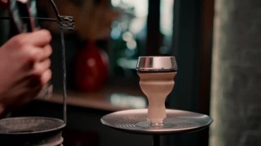 Nargile kasesini kapatın. Arka planda yanan kömürler var. Dinlenme odası nargile sigara içme konseptinde.