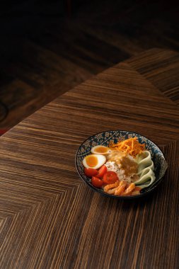 Doğu restoranında sosla kaplanmış sebzeli somon ve pirinçli lezzetli bir kase sağlıklı Asya yemeği.