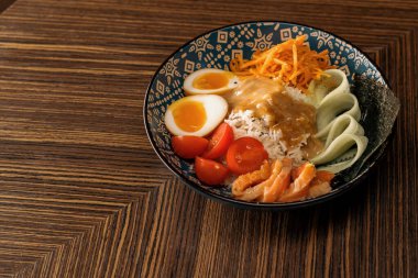 Doğu restoranında sosla kaplanmış sebzeli somon ve pirinçli lezzetli bir kase sağlıklı Asya yemeği.