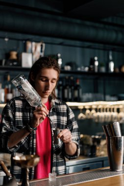 Profesyonel bir barmen ölçü kabına alkol döker. Barda yakın plan bir kulüpte kokteyl hazırlama süreci.