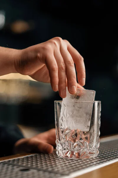 알코올음료를 준비하면서 유리잔에 크리스탈 얼음을 바텐더의 모습을 클로즈업 — 스톡 사진