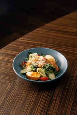 İştah açıcı taze somonlu salata restoranın sağlıklı vejetaryen yemeklerinde masada.