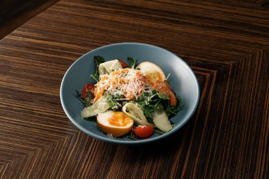 İştah açıcı taze somonlu salata restoranın sağlıklı vejetaryen yemeklerinde masada.