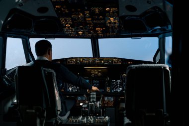 The pilot in the cockpit of the aircraft turbulence during flight Flight simulator navigation devices clipart