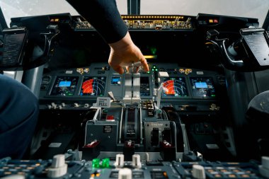 Bir uçak pilotu uçuş sırasında gaz kolunu kontrol eder. Kabinin içinden görüntüyü alır.