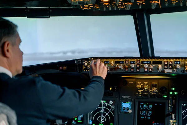飞行员按控制面板上的动力按钮控制驾驶舱挡风玻璃前面的飞机 — 图库照片