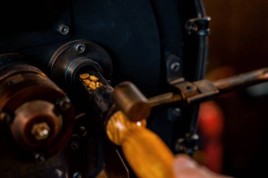 Bir işçi kahve çekirdeklerine bakar ve kahve makinesinde kavrulduktan sonra kahve kalitesini kontrol eder.