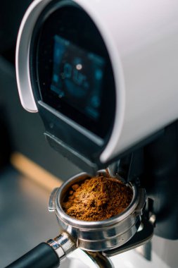 Profesyonel barista işçisi, kahve dükkanı yapmak için taze kahve çekirdeklerini öğütmek için öğütücü makine kullanır.