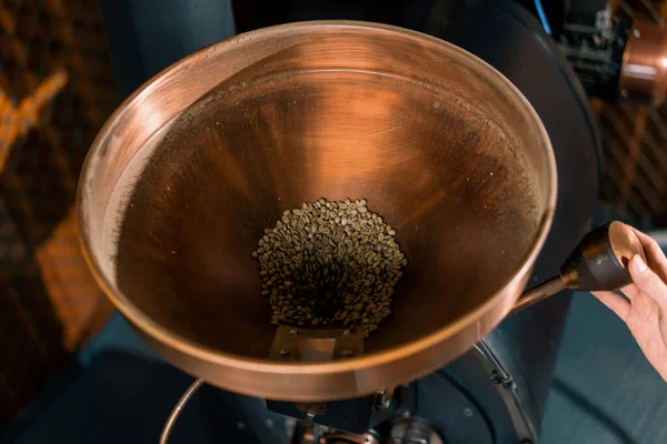 咖啡烘焙工艺商人将生咖啡豆倒入一家工厂的现代烘焙机 — 图库照片