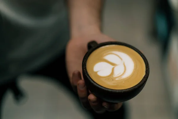 咖啡店服务员在咖啡杯里给顾客端热咖啡拿铁 用牛奶煮热咖啡 — 图库照片