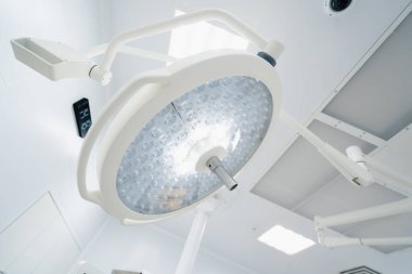 Ameliyathane tavanında büyük yuvarlak modern lambalar günümüz kliniklerinde gelişmiş aydınlatma ekipmanları ameliyatları