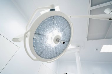 Ameliyathane tavanında büyük yuvarlak modern lambalar günümüz kliniklerinde gelişmiş aydınlatma ekipmanları ameliyatları
