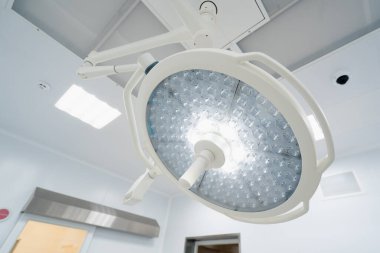 Ameliyathane tavanında büyük yuvarlak modern lambalar günümüz kliniklerinde gelişmiş aydınlatma ekipmanları ameliyatları