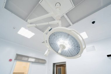 Ameliyathane tavanında büyük yuvarlak modern lambalar günümüz kliniklerinde gelişmiş aydınlatma ekipmanları ameliyatları