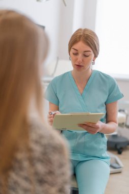 Jinekolog, jinekoloji ofisindeki modern bir klinikte tıbbi danışma sırasında bir hastayla konuşur.