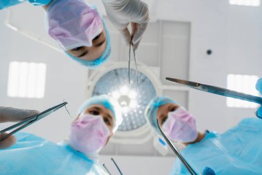 Hastanenin alt katında cerrahi aletler tutan bir grup doktor ve hemşire.