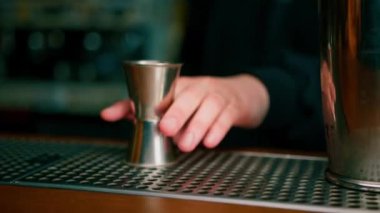 Kokteyl hazırlayan profesyonel barmen deneyimli barmen karıştırıcıya alkollü bir içecek koyar.