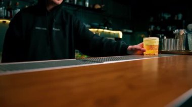 Barmen müşteriye bardan salatalık dilimleyicisiyle birlikte nefis bir cin bahçesi alkollü kokteyli verir.