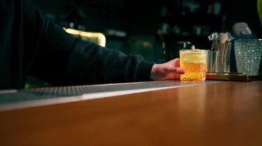 Barmen müşteriye bardan salatalık dilimleyicisiyle birlikte nefis bir cin bahçesi alkollü kokteyli verir.
