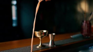 Barda kokteyl hazırlama süreci A barmeninin alkollü kokteyl malzemelerini karıştırarak karıştırması.