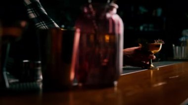 Barmen müşteriye bardan yeni hazırlanmış lezzetli bir kokteyl verir.