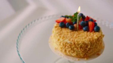 Taze yapılmış lezzetli pasta Napolyon Puf böreği taze çilek ve meyveli pasta. Pastanın içinde mum yanıyor.