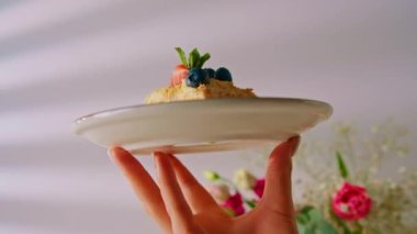 Napolyon pastası, elinde çilek ve böğürtlen tabağıyla.