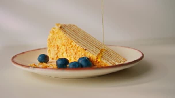 美味的新鲜蜂蜜蛋糕 盘中撒满了蜂蜜 还有白色背景甜点的概念 — 图库视频影像