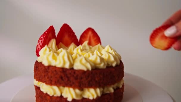 焼きたてのイチゴでお菓子を飾りますバターアイシングで飾られた白い背景においしいケーキ 赤いベルベット — ストック動画