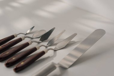 Beyaz arka planda, masadaki pastalar için spatulaların farklı türleri pişirme aletleri.