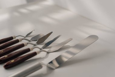 Beyaz arka planda, masadaki pastalar için spatulaların farklı türleri pişirme aletleri.