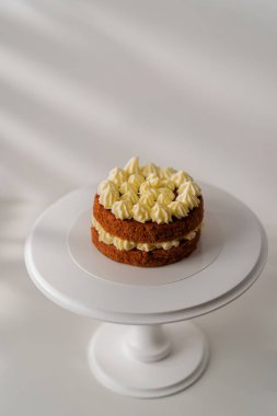 Tereyağlı süslemeyle süslenmiş beyaz arka planda yeni hazırlanmış kırmızı kadife kek.