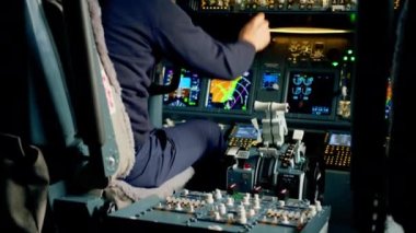 Bir uçak pilotu uçuş sırasında gaz kolunu kontrol eder. Kabinin içinden görüntüyü alır.