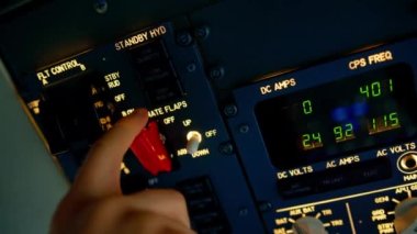 Pilot, yolcu gemisini kalkışa hazırlamak için düğmelere basarak uçağın elektronik aletlerini kontrol ediyor.