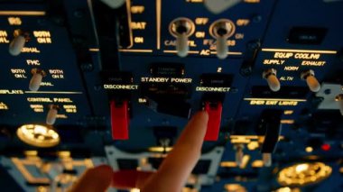 Pilot, yolcu gemisini kalkışa hazırlamak için düğmelere basarak uçağın elektronik aletlerini kontrol ediyor.