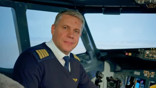 身着制服 面带微笑的机长为飞行模拟器驾驶舱作准备的画像 — 图库视频影像