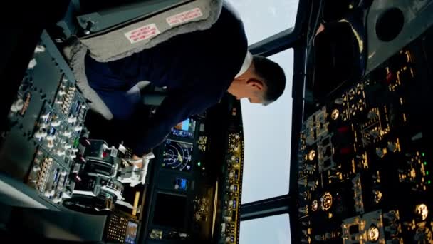 商用航空機パイロットは キャビン垂直ビデオからの高高度飛行ビュー中に航空機の飛行パラメータを調整する — ストック動画