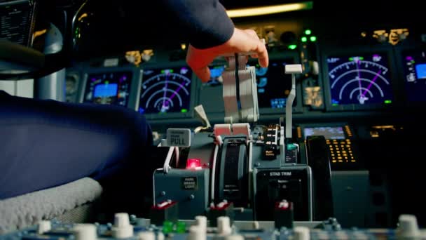 Gros plan de la main d'un pilote pressant la manette des gaz dans le poste de pilotage d'un avion à réaction réduisant la puissance du moteur