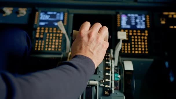 ジェット飛行機のコックピットでスロットルを押すパイロットの手の近くにエンジンの力を減らす — ストック動画