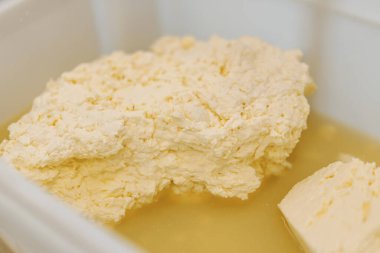 Üretim için yumuşak peynir kalıpları dolduruluyor Peynir tuzlu suya batırılıyor.