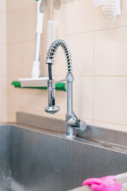 Bulaşık makinesi üretim musluğunda yakın çekim çamaşır aksesuarları.