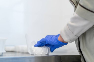 Bir işçi elle organik yumuşak peyniri kâğıt ambalajına koyar. Peynir üretimini yakından yapar.