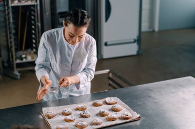 Çekici fırıncı pudra şekeri hazır taze kokulu çörekler üretim fırını.