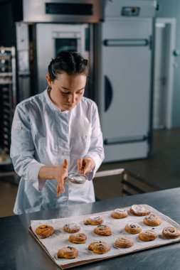 Çekici fırıncı pudra şekeri hazır taze kokulu çörekler üretim fırını.