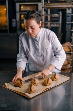 Fırıncı bıçakla kesiyor taze pişmiş çıtır çıtır ve yumuşak ekmek fırınında pişiriyor. Profesyonel mutfak.