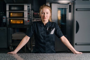 Profesyonel mutfakta çalışmaya başlamadan önce iş yerinde üniformalı profesyonel bir şekerci duruyor.