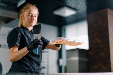 Profesyonel bir şekerci, profesyonel mutfak için spatula ile dökülen çikolatayı kalıba döker.
