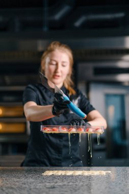 Profesyonel bir şekerci, profesyonel mutfak için spatula ile dökülen çikolatayı kalıba döker.