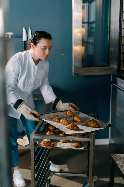 Atrakcyjny Piekarz Przyjmuje Gotowe Bułki Rogaliki Profesjonalne Piekarnia Produkcja Świeżych — Zdjęcie stockowe